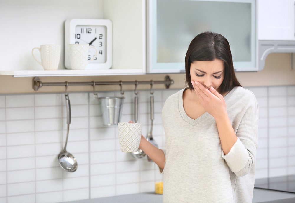 Beautiful pregnant woman suffering of nausea in kitchen